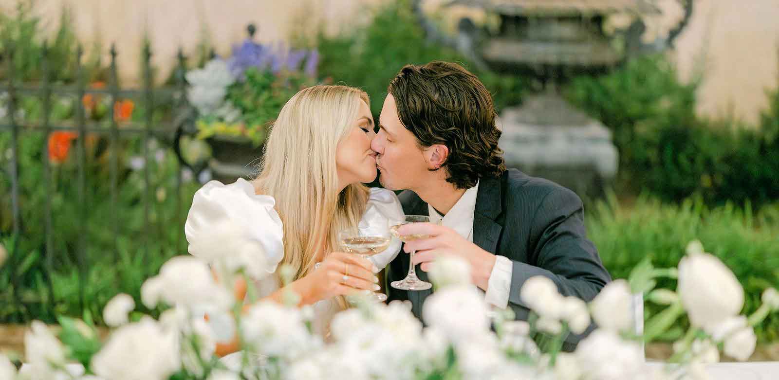 Photo of two newlyweds kissing at a wedding reception